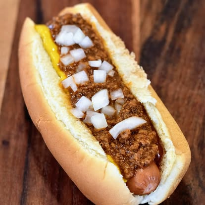 Just Johnny chili dog with mustard, ketchup, and onions
